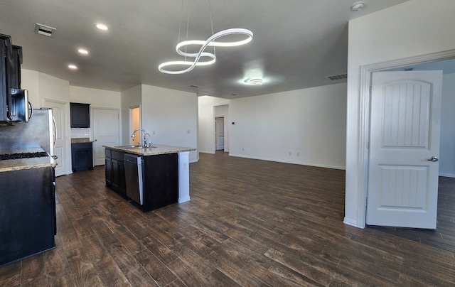 kitchen with stainless steel dishwasher, dark wood-type flooring, dark cabinets, and a sink