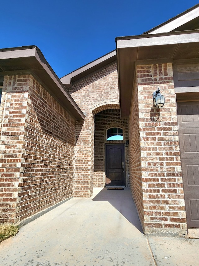 entrance to property featuring brick siding