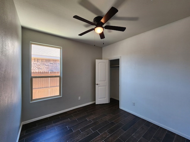 spare room featuring wood finish floors, baseboards, and a ceiling fan