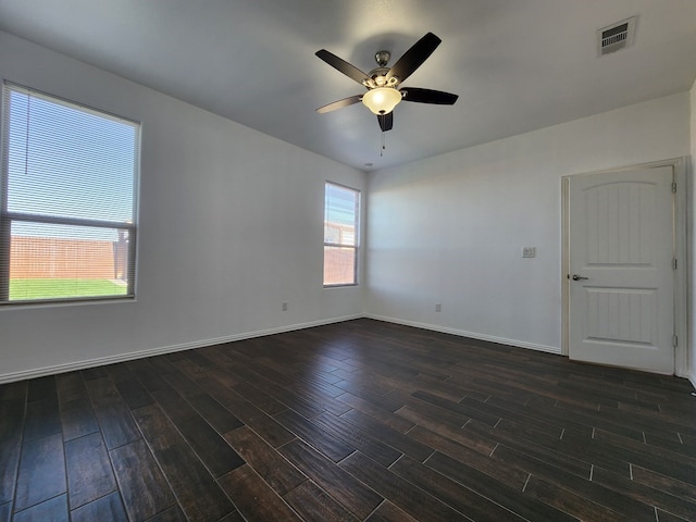 unfurnished room featuring a ceiling fan, dark wood-style floors, visible vents, and baseboards