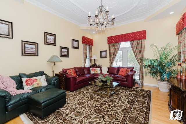 living room featuring hardwood / wood-style floors, crown molding, and a chandelier