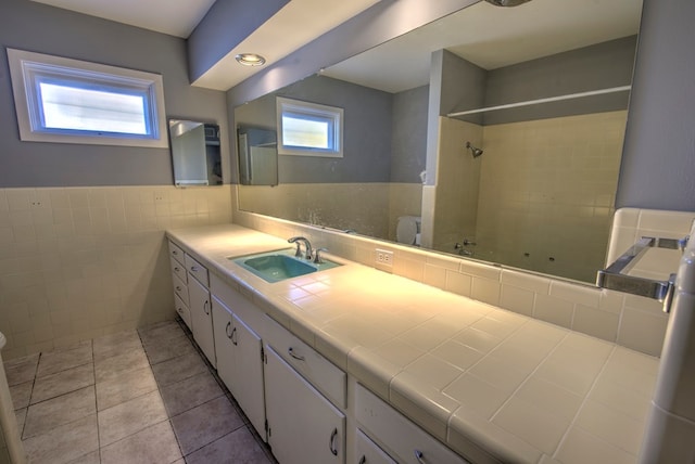 bathroom with tile walls, vanity, and tile patterned floors