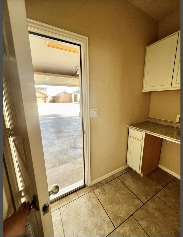 entryway with tile patterned flooring and baseboards