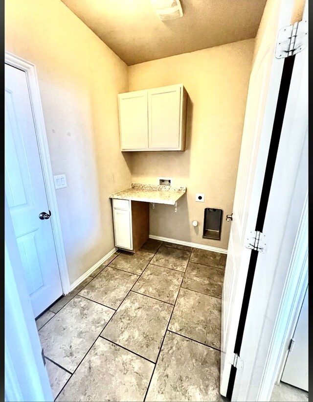 laundry room featuring cabinet space, electric dryer hookup, hookup for a washing machine, an office area, and light tile patterned flooring