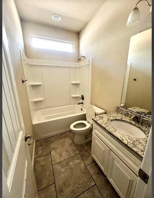 bathroom featuring a textured ceiling, bathtub / shower combination, toilet, vanity, and a textured wall