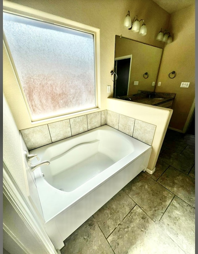 full bathroom featuring a garden tub, tile patterned flooring, and a sink