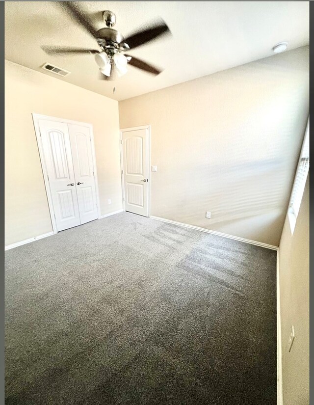 unfurnished bedroom with baseboards, carpet, a closet, and a ceiling fan