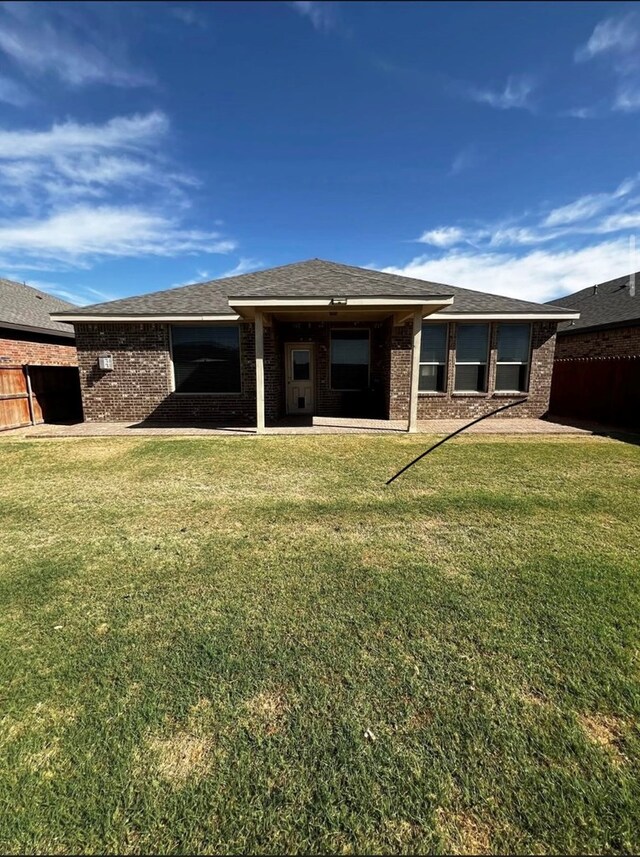 rear view of property featuring brick siding and a shingled roof