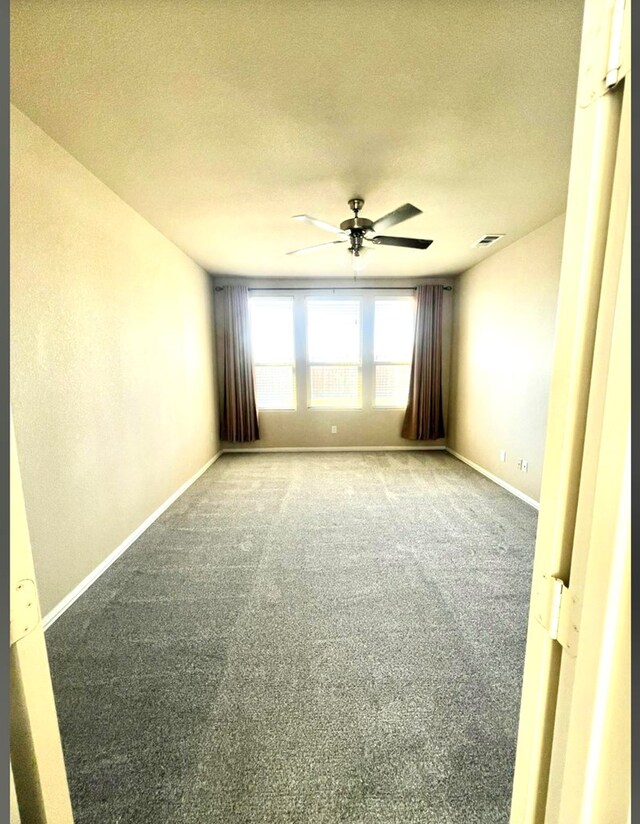 carpeted spare room featuring a ceiling fan, baseboards, and a textured ceiling