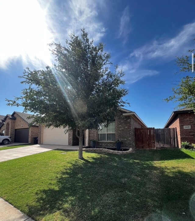 view of property hidden behind natural elements with brick siding, driveway, and an attached garage