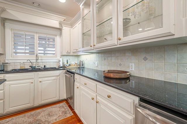 kitchen with a sink, backsplash, and stainless steel dishwasher