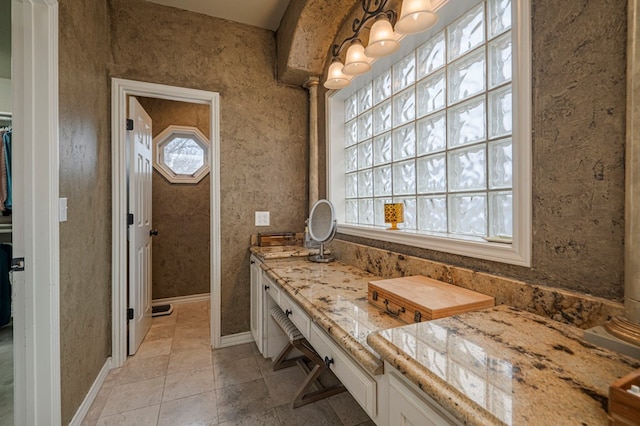 bathroom with tile patterned flooring, baseboards, and a wealth of natural light