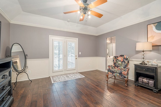 foyer entrance with a tray ceiling, a wainscoted wall, crown molding, and wood finished floors