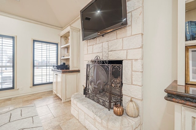 room details featuring ornamental molding and a fireplace with raised hearth