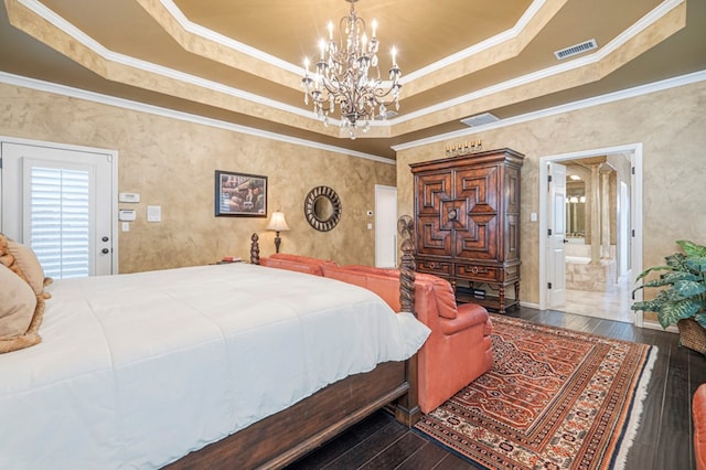 bedroom with a tray ceiling, visible vents, and hardwood / wood-style flooring