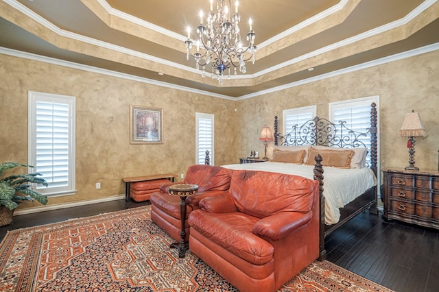 bedroom featuring baseboards, wood finished floors, a tray ceiling, crown molding, and a notable chandelier