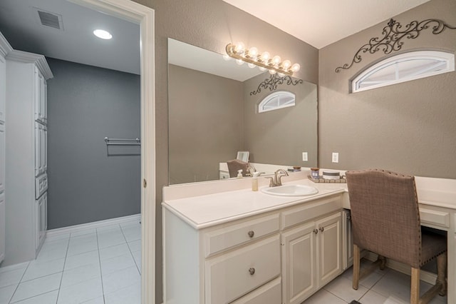 bathroom featuring baseboards, visible vents, a textured wall, tile patterned floors, and vanity