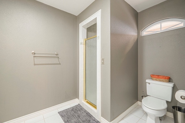 full bath featuring baseboards, a shower stall, toilet, and tile patterned floors