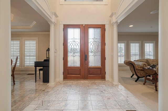 foyer with ornate columns, crown molding, and french doors