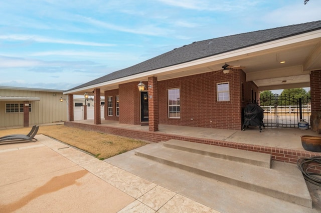 back of house featuring a shingled roof, fence, a patio, and brick siding