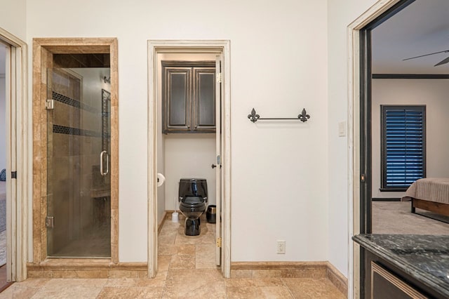 full bathroom with connected bathroom, a ceiling fan, baseboards, a shower stall, and stone finish flooring