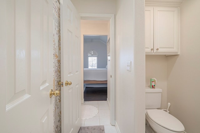 bathroom with connected bathroom, toilet, and tile patterned floors