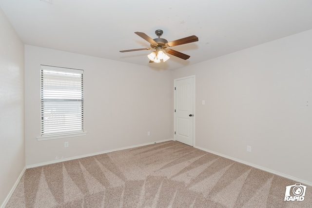 unfurnished room with baseboards, carpet, and a ceiling fan