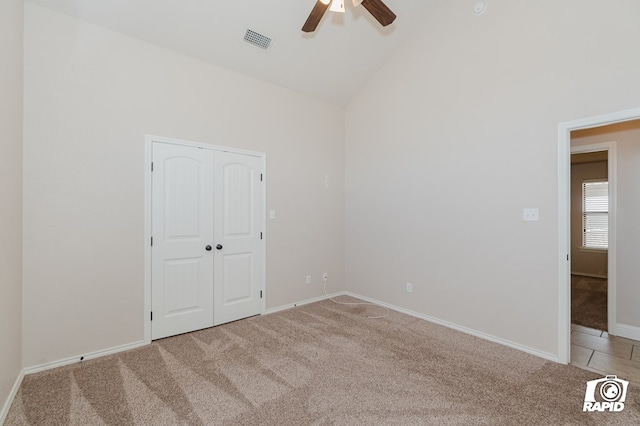 unfurnished bedroom with visible vents, ceiling fan, light carpet, a closet, and high vaulted ceiling