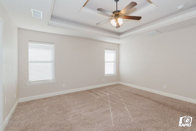 unfurnished room with visible vents, a ceiling fan, a raised ceiling, and baseboards