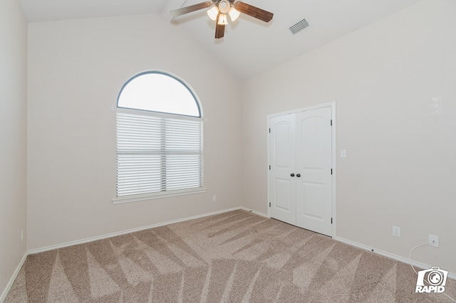 empty room with visible vents, vaulted ceiling with beams, baseboards, carpet flooring, and a ceiling fan