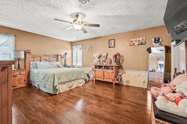3804 Cedar Spg, Midland, TX 79703 - bedroom with a textured ceiling, wood finished floors, a wainscoted wall, and ceiling fan