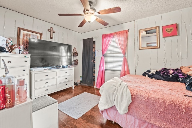 3804 Cedar Spg, Midland, TX 79703 - bedroom with dark wood-type flooring, a textured ceiling, a ceiling fan, and wood walls