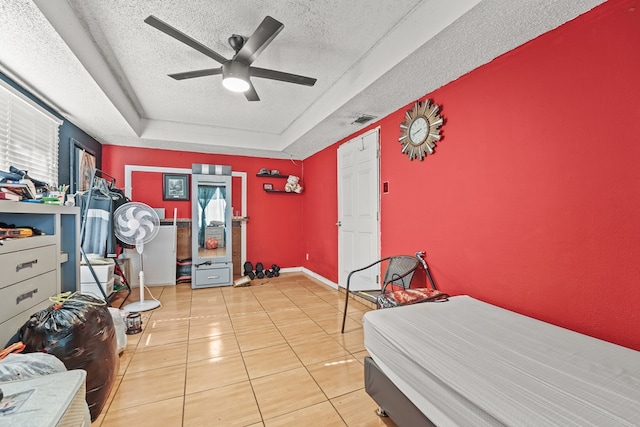 3804 Cedar Spg, Midland, TX 79703 - tiled bedroom featuring a textured ceiling, a tray ceiling, and a ceiling fan