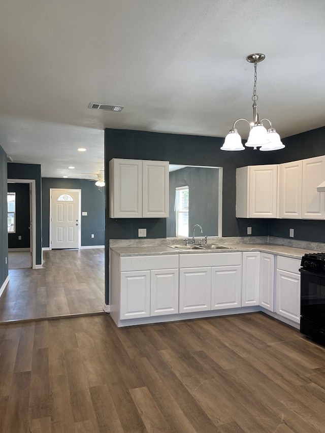 1208 W Tennessee Ave, Midland, TX 79701 - kitchen with a sink, black range with gas stovetop, dark wood-style floors, and white cabinets
