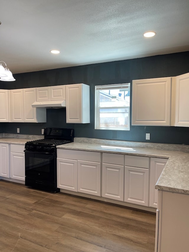 1208 W Tennessee Ave, Midland, TX 79701 - kitchen featuring black range with gas cooktop, under cabinet range hood, white cabinets, light countertops, and dark wood finished floors