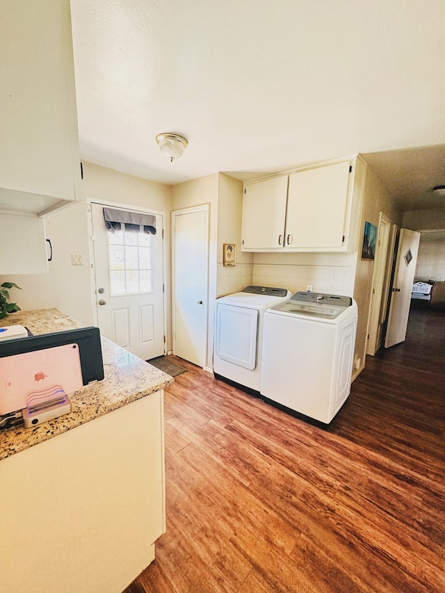 laundry room featuring hardwood / wood-style flooring, cabinets, and independent washer and dryer