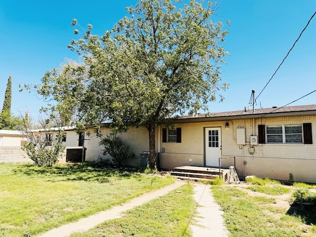 view of front of house featuring central AC and a front lawn