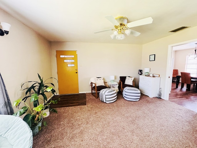 living area featuring ceiling fan and carpet