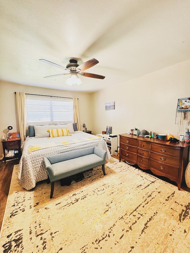 bedroom with dark hardwood / wood-style flooring and ceiling fan