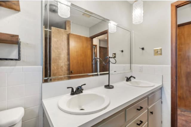 bathroom featuring tile walls, toilet, and vanity