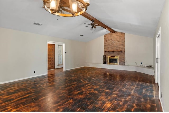 unfurnished living room with ceiling fan, dark wood-type flooring, a large fireplace, and lofted ceiling with beams