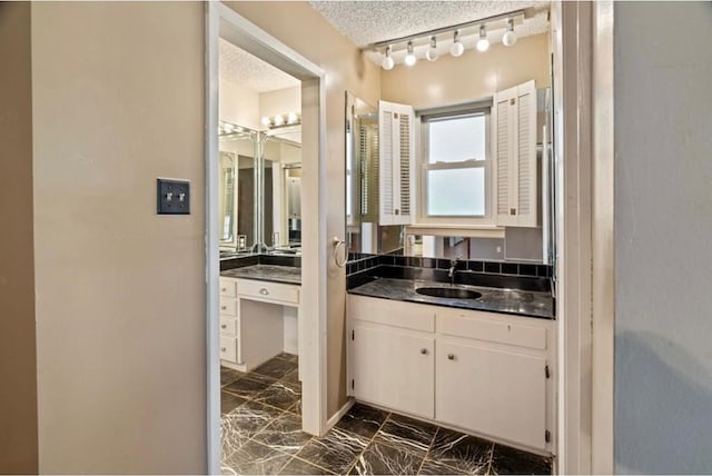 bathroom featuring a textured ceiling and vanity