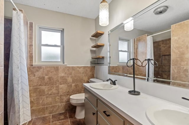 bathroom featuring toilet, tile walls, vanity, and curtained shower