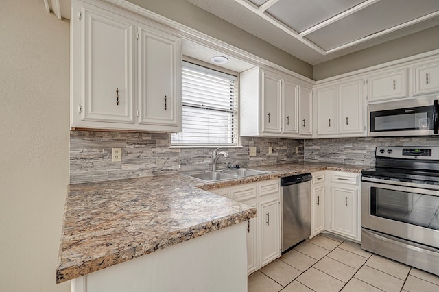 3205 Dentcrest Dr Unit B, Midland, TX 79707 - kitchen featuring stainless steel appliances, a sink, decorative backsplash, light tile patterned floors, and white cabinetry