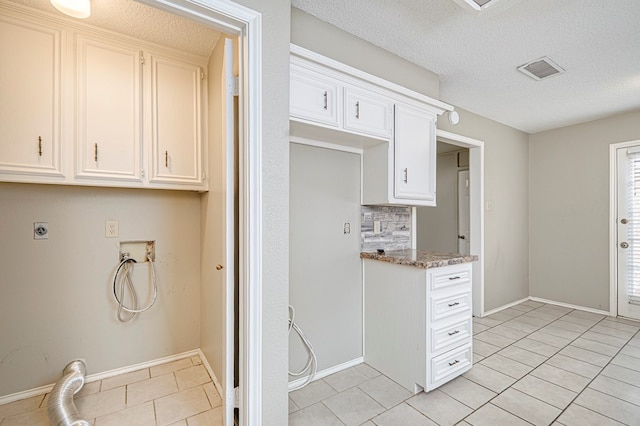 3205 Dentcrest Dr Unit B, Midland, TX 79707 - laundry area featuring hookup for an electric dryer, light tile patterned floors, washer hookup, a textured ceiling, and baseboards