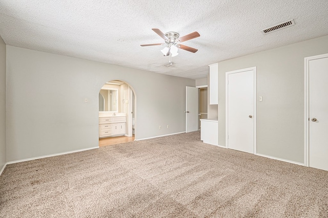3205 Dentcrest Dr Unit B, Midland, TX 79707 - unfurnished room with light colored carpet, ceiling fan, arched walkways, baseboards, and a textured ceiling