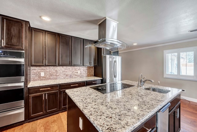 1002 Boyd Ave, Midland, TX 79705 - kitchen with stainless steel appliances, a sink, island range hood, light wood-style floors, and a warming drawer