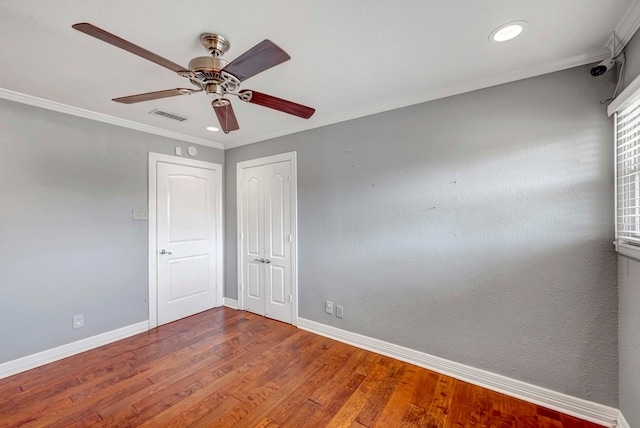 1002 Boyd Ave, Midland, TX 79705 - spare room with visible vents, crown molding, baseboards, ceiling fan, and wood finished floors