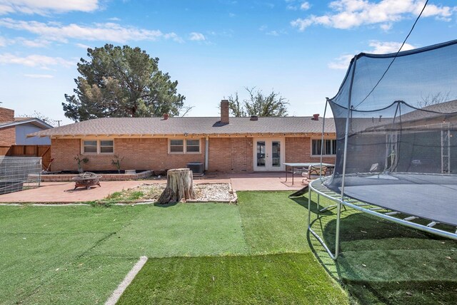 1002 Boyd Ave, Midland, TX 79705 - rear view of house featuring a patio, brick siding, a trampoline, and french doors