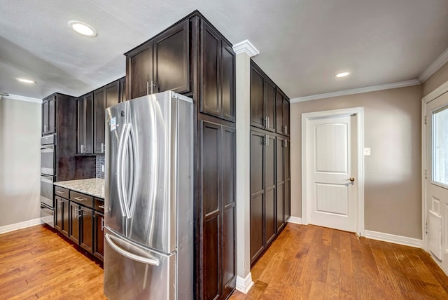 1002 Boyd Ave, Midland, TX 79705 - kitchen with dark brown cabinets, light wood-style floors, ornamental molding, and stainless steel appliances